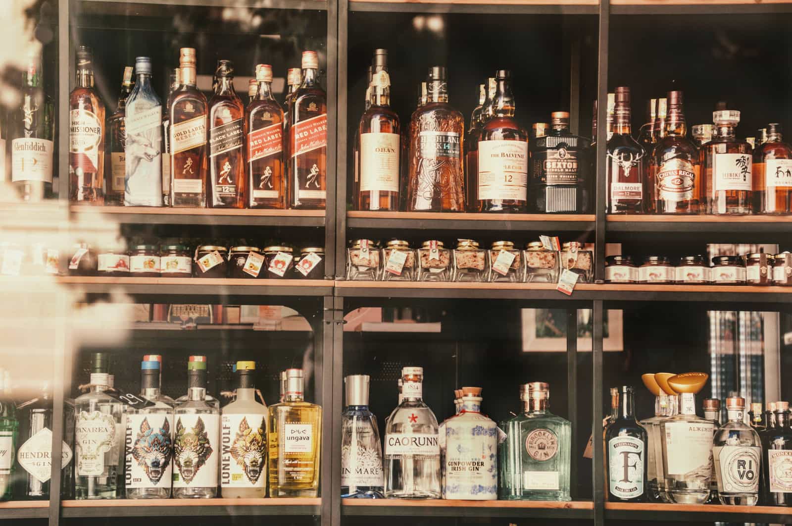 A stocked back bar lined with spirit bottles and glassware