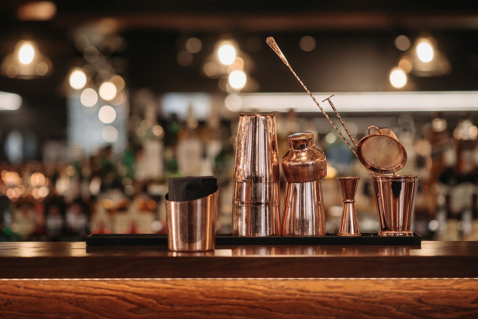 Copper bar tools lined up in a row on a bar top