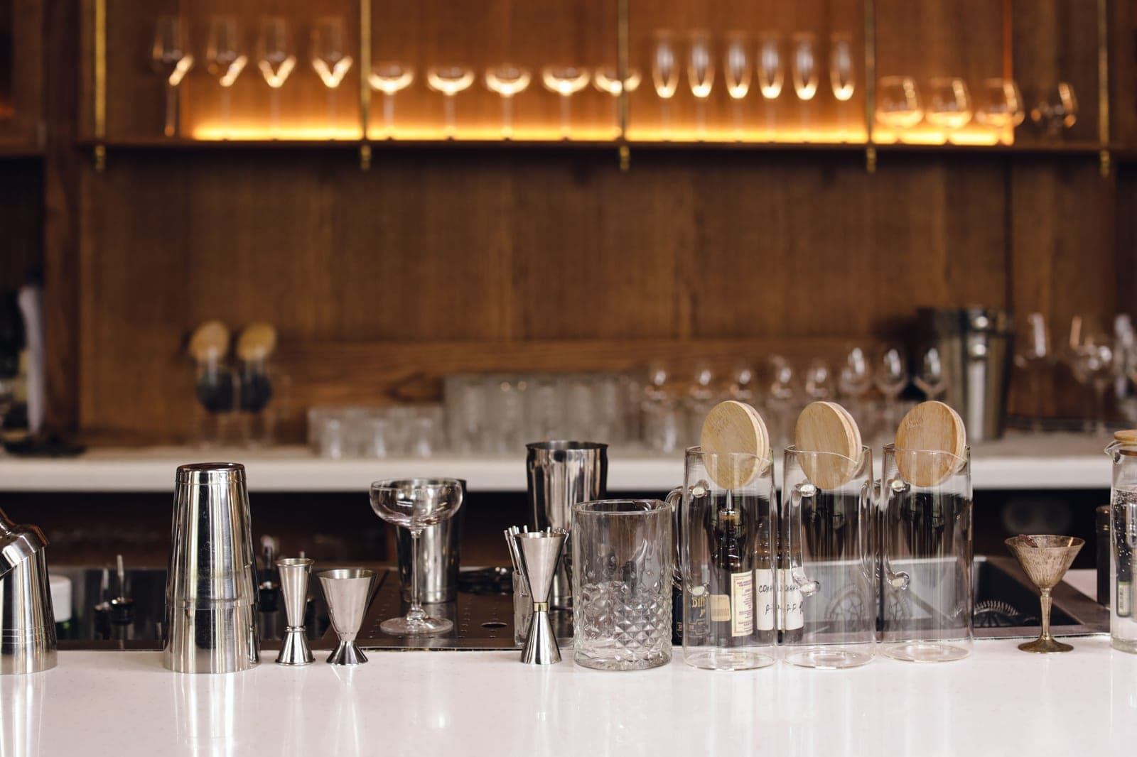 Bar tools and glassware arranged on a bright counter