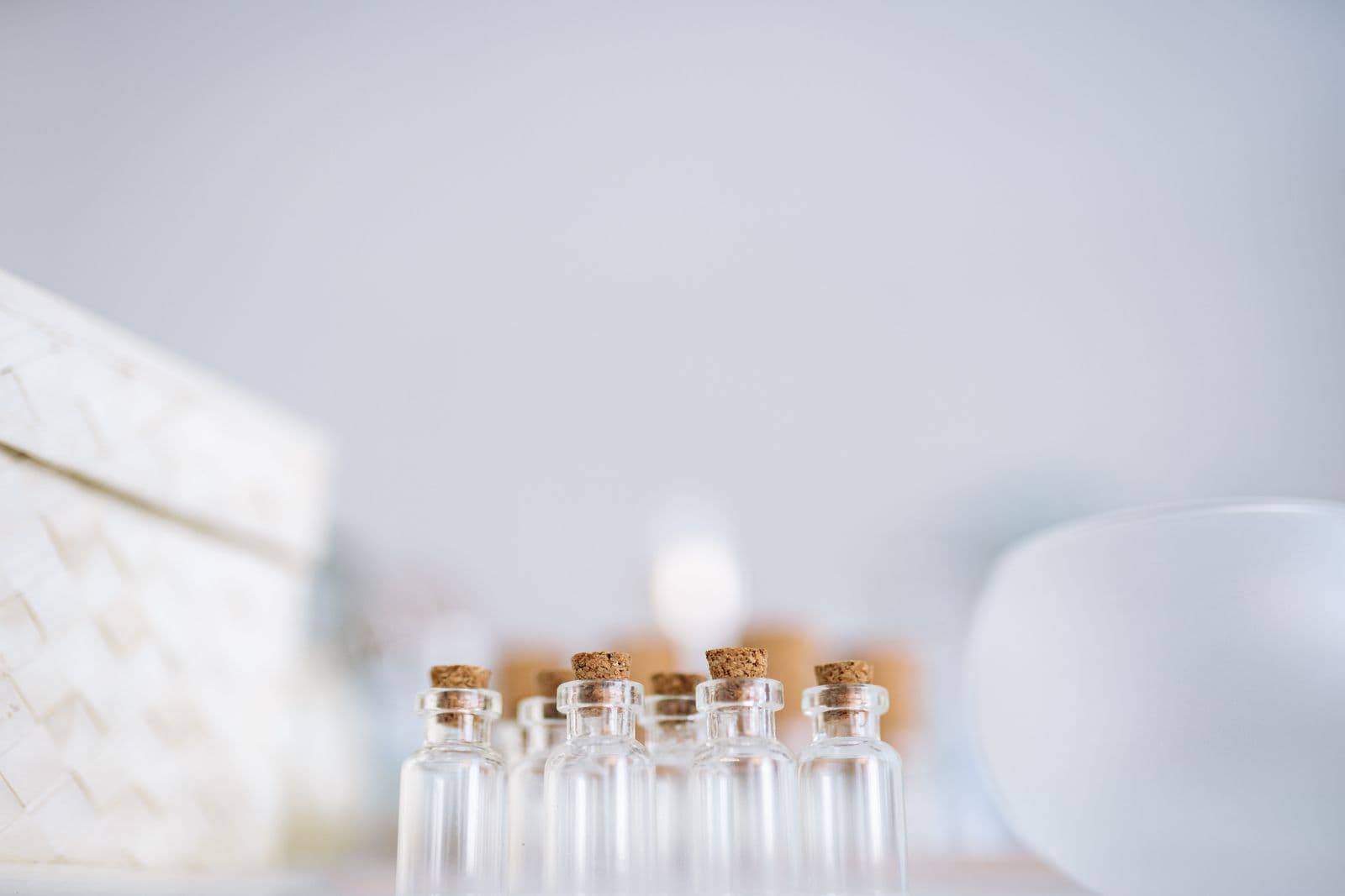 Several corked glass bottles in a row against a pale background