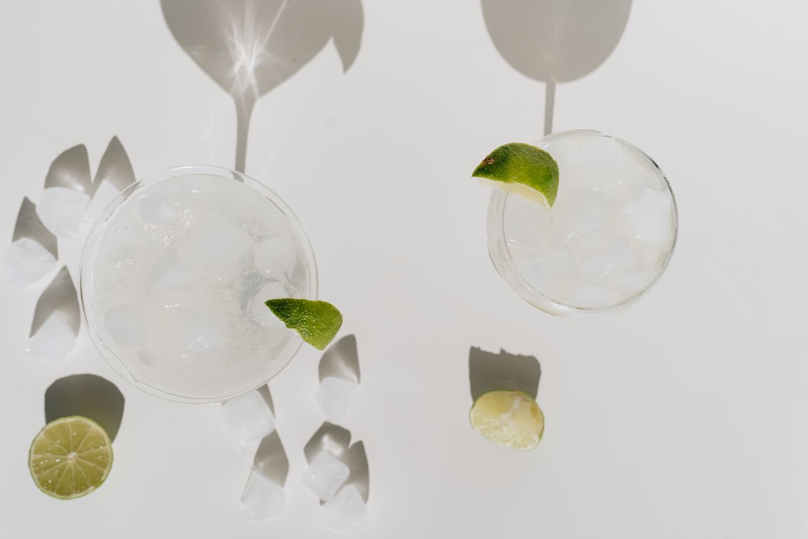Lime margaritas with ice, shot from above on a bright surface