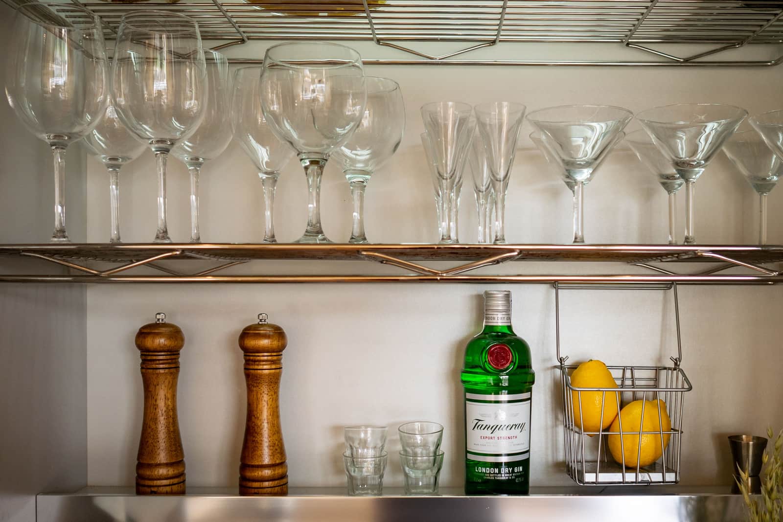A set of cocktail glasses on a bright shelf