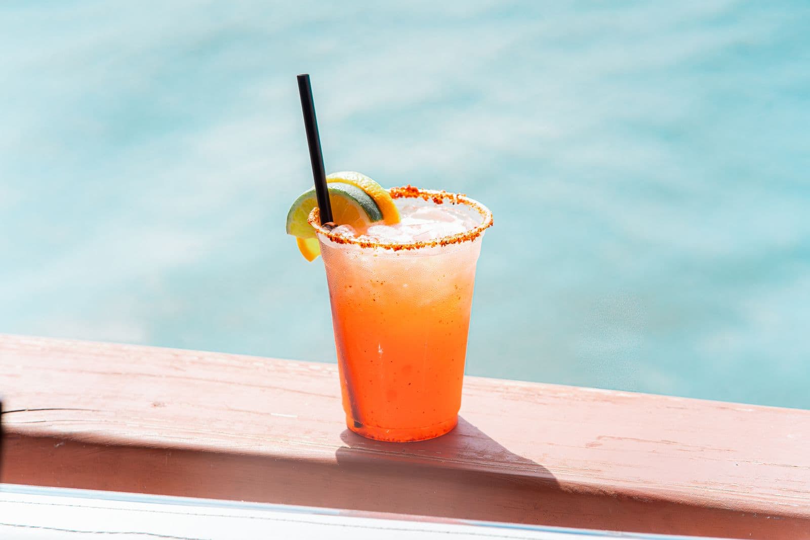 A margarita with lime and orange garnish in bright daylight