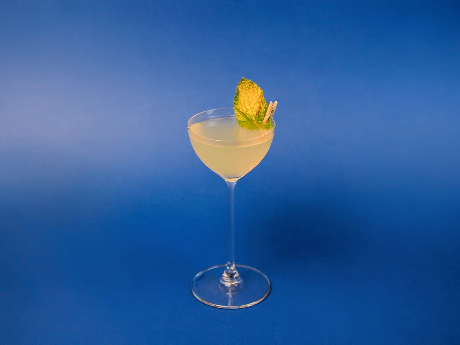 A small stemmed cocktail glass on a bright minimal surface