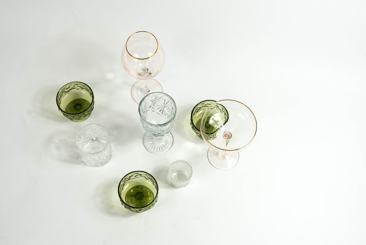 Empty coupe cocktail glasses on a bright table
