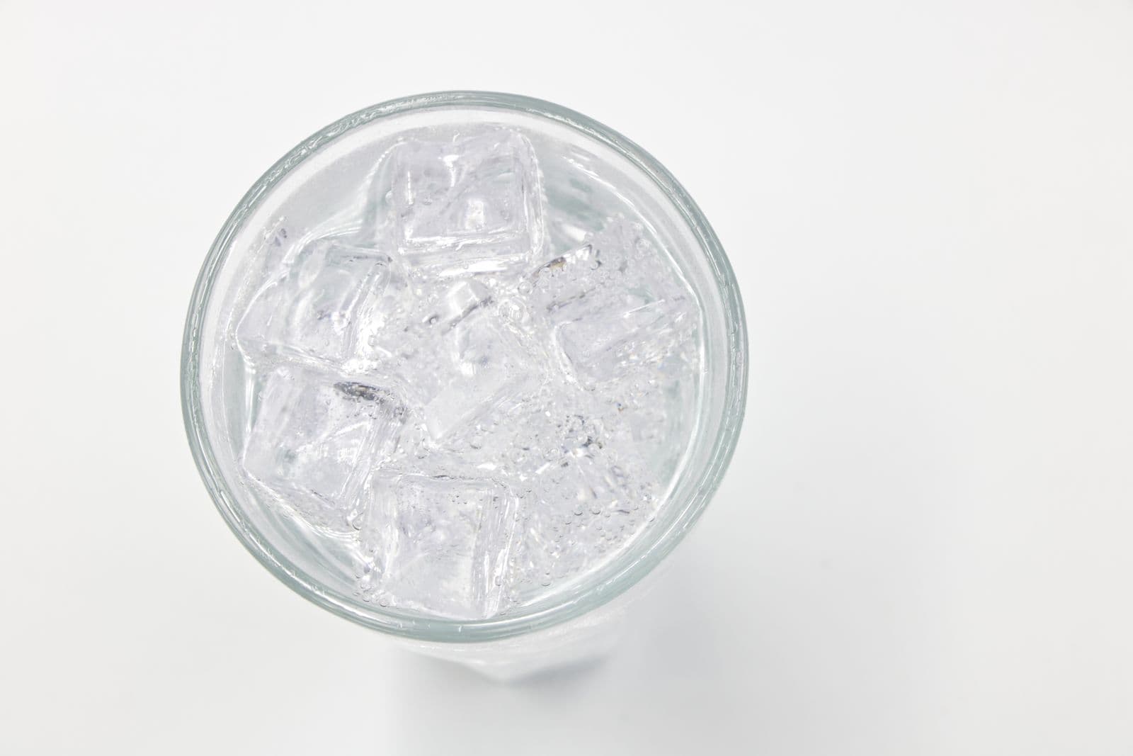 A glass filled with ice on a white background